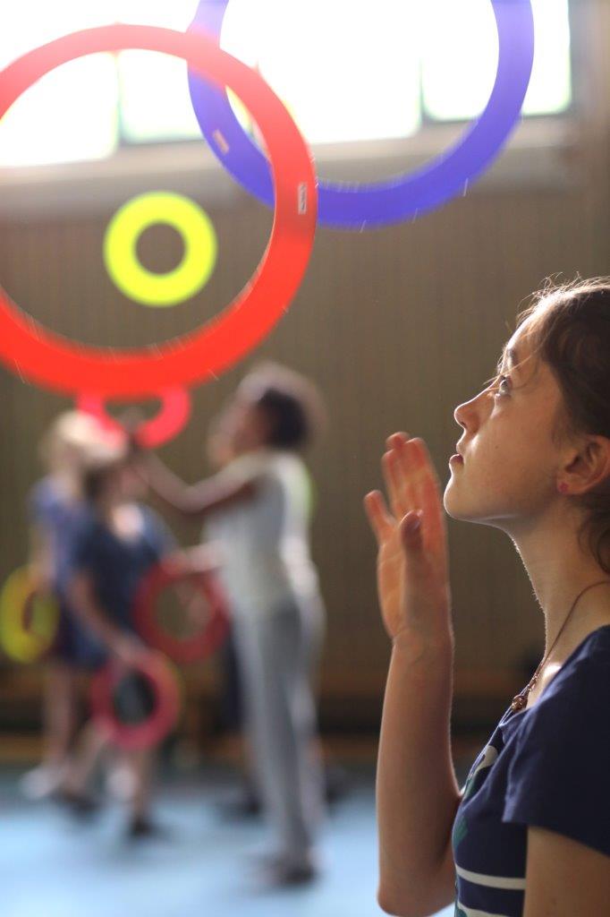 Mädchen jongliert mit bunten Ringen