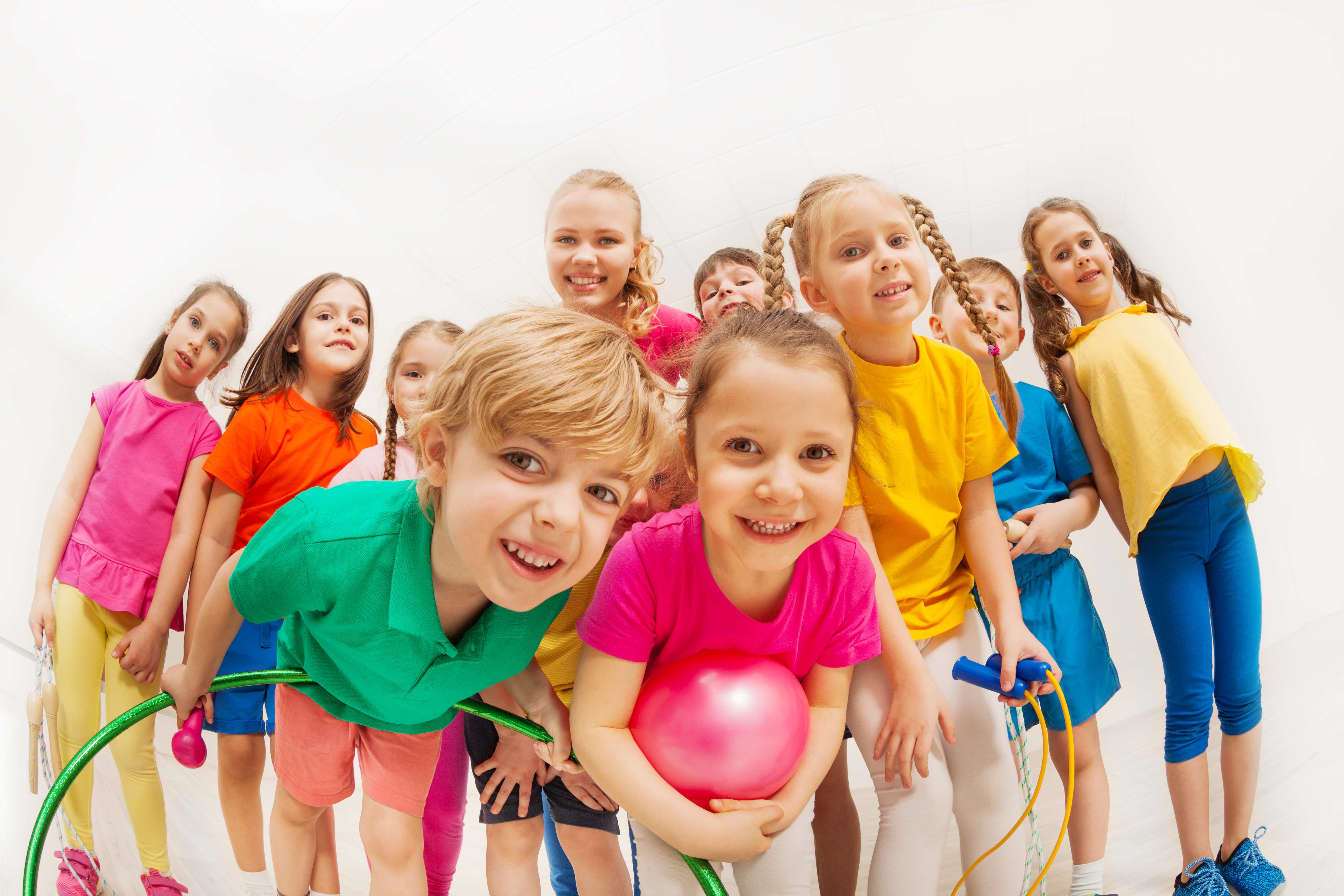 Gruppe von Kindern mit Gymnastikball und Hulla-Hoop-Ring