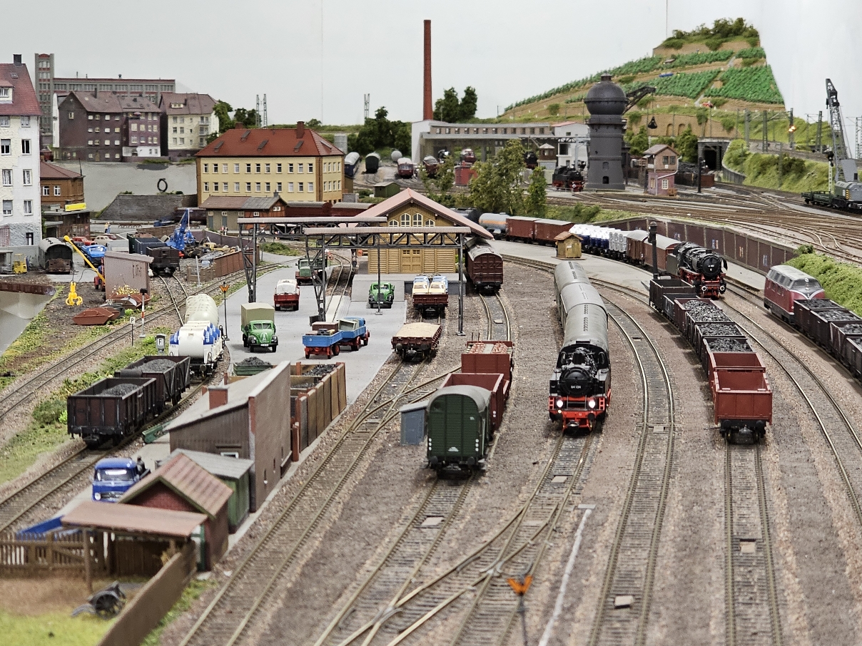 © Modellbahn 65 Ansicht auf eine Modelleisenbahn-Anlage mit Modell-Stadt im Hintergrund.