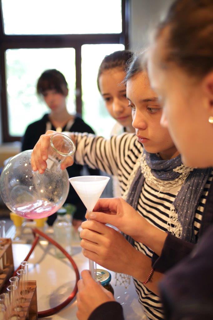 Mädchen experimentieren im Chemie-Unterricht mit einer Retorte