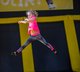 Mädchen springt auf einem großem Trampolin.