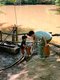 Jungen spielen an einer Wasser-Spielstation.