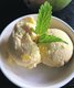 Eine Schale mit zwei Kugeln Mango-Eis, als Dekoration mit einem Pfefferminzblatt.