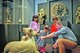 Drei kleine Kinder und ein Vater stehen in einer Ausstellung im Linden-Museumj Stuttgart und sehen sich ein auf dem Boden stehendes Exponat an.