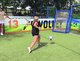 Eine blonde Frau spielt Fußballgolf auf dem Campo del Sol in Großbottwar und schießt gerade im Laufen einen Fußball in ein kleines, blaues Tor mit weißem Netz.