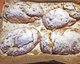 Zu sehen sind vier frisch gebackene Stollen mit Puderzucker bestreut.