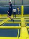 Drei junge Männer in Sportkleidung springen auf den schwarz-gelben Trampolinen der Sprungbude Filderstadt.