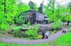 Das Foto zeigt das Haus des Waldes Stuttgart von vorne, es ist umgeben von vielen Bäumen und vor dem Haus verläuft ein Waldweg.