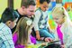 Ein junger Mann liest mehreren Kindern vor.