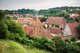 Das Foto zeigt das Kloster Maulbronn umgeben von vielen Bäumen von oben, der Himmel ist bewölkt.