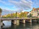 Innenstadt von Straßburg. Eine Brücke führt über einen Fluss.