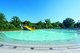 Man sieht auf dem Foto das noch leere Kinderbecken mit der gelben Rutsche im Freibad Ludwigsburg Hoheneck bei strahlend blauem Himmel.
