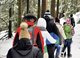 Auf dem Bild ist eine Wandergruppe zu sehen, die durch den Winterwald geht.