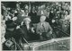 Elly und Theodor Heuss sitzen in einem offenen Auto und winken der Menge zu.