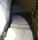 Alte Steintreppe führt in ein dunkles Gewölbe.